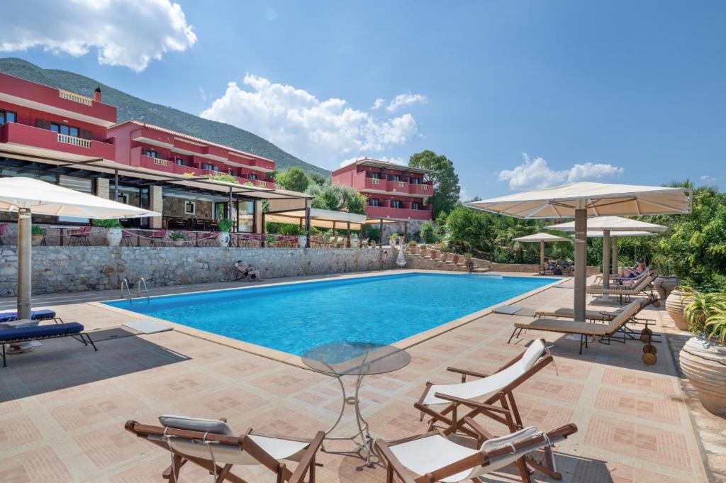 a pool at a hotel with chairs and umbrellas at Hotel Aristotelis in Ancient Epidauros