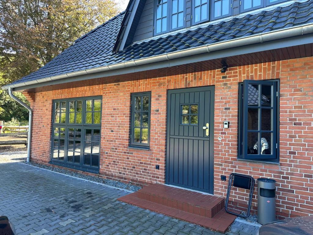 a brick house with a dog looking out the door at Matzens Hus in Handewitt
