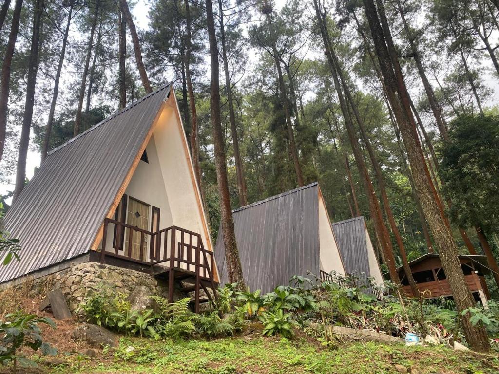 a small cabin in the woods with trees at The Nest Park in Prigen
