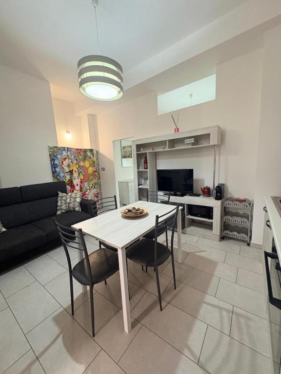 a kitchen and living room with a table and chairs at Il gingillo di Alice by Maniel Beach Hotel in Letojanni