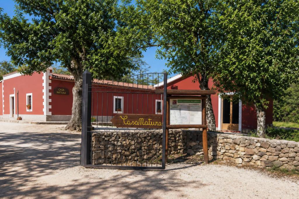 a sign in front of a red building at Casa Natura Gargano in Monte SantʼAngelo