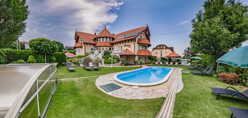 a large house with a swimming pool in the yard at Fortuna Villa in Hévíz