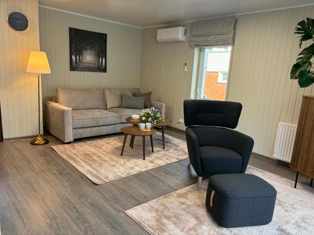 a living room with a couch and chairs and a table at Apartamentai Kelmėje in Kelmė