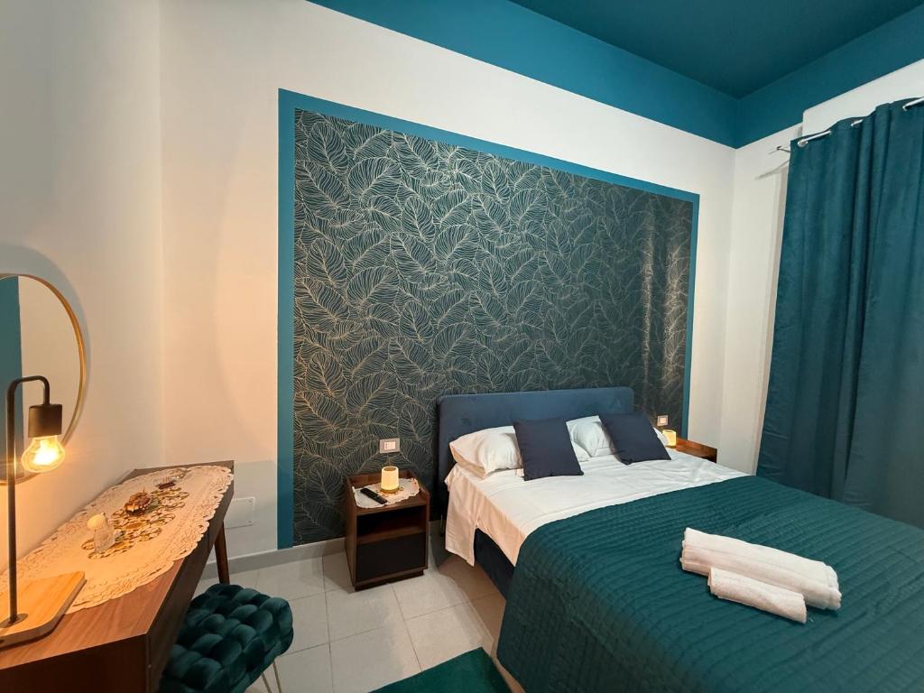 a bedroom with a bed and a blue wall at Da Nonna Maria in Roccalumera