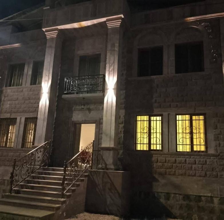 a stone building with stairs and windows at night at Мгер Мелконян in Tsaghkadzor