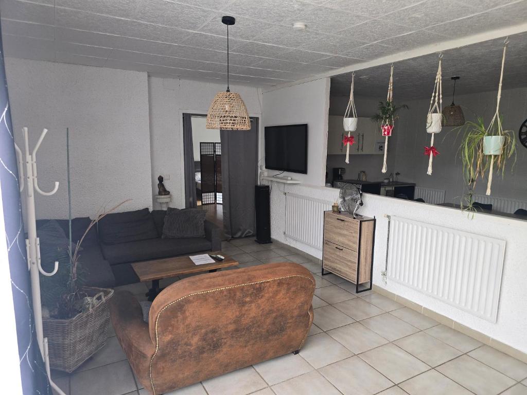 a living room with a couch and a table at Un petit coin de paradis in Gavarret