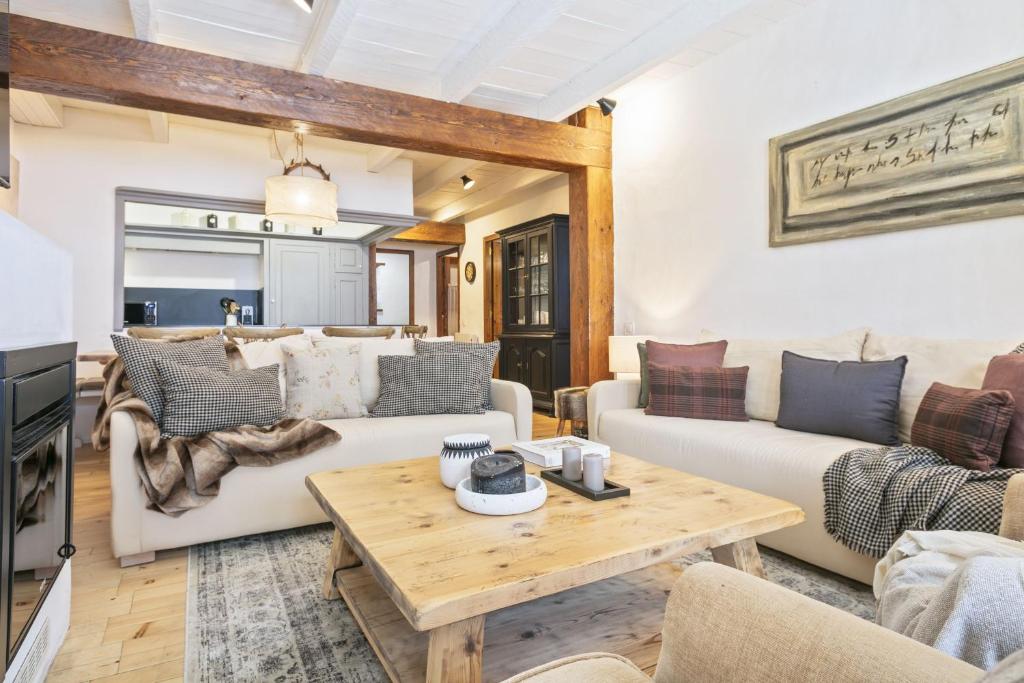 a living room with two couches and a table at Luderna - Apartamento con terraza Eth Picot in Tredós