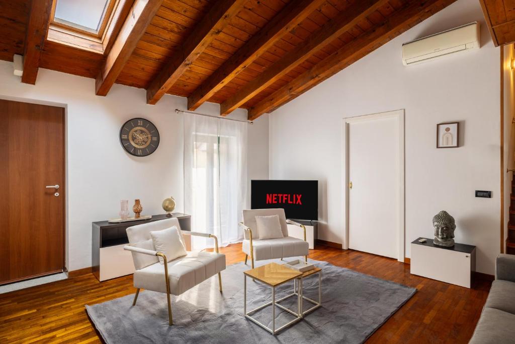 a living room with white furniture and a tv at Lodge Fiera Milano in Rho