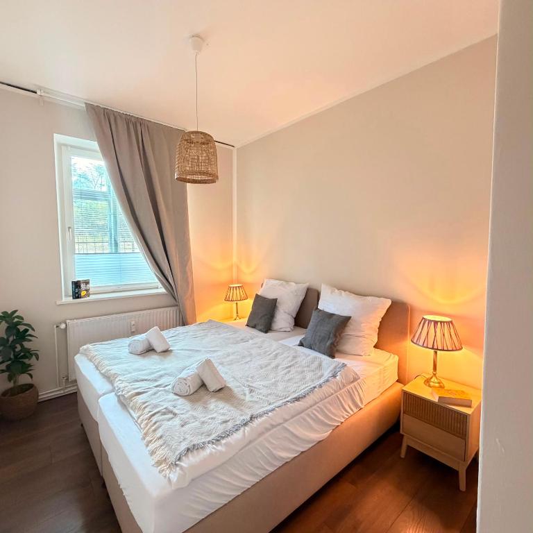 a bedroom with a large white bed with two pillows at HYGGE HOMES Apartment - 'nordlys' in Lüneburg