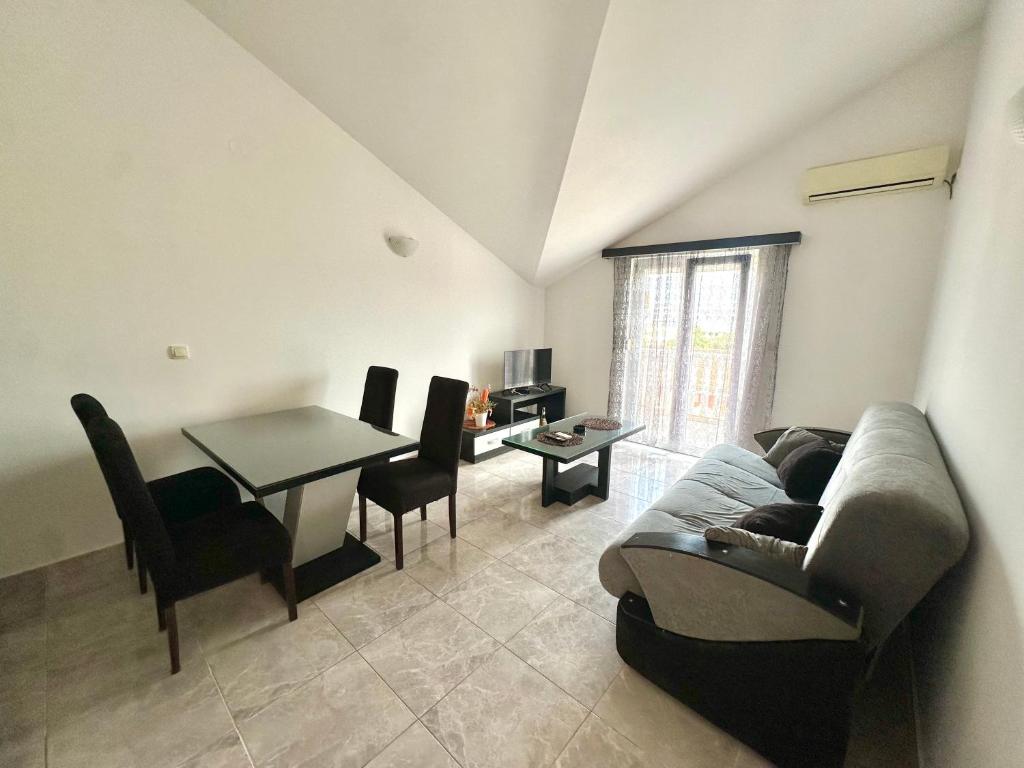 a living room with a couch and a table at SeaSide Holiday Apartment in Bijela