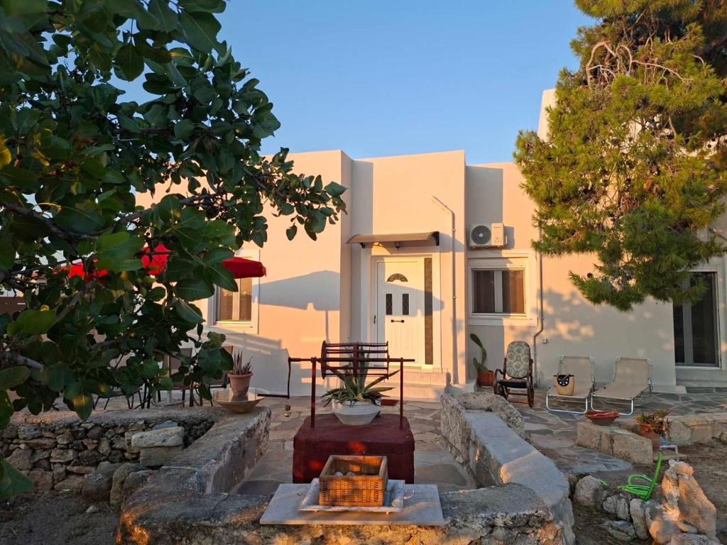 a house with white walls and trees in front of it at Mitsakos Golden Villa in Egina