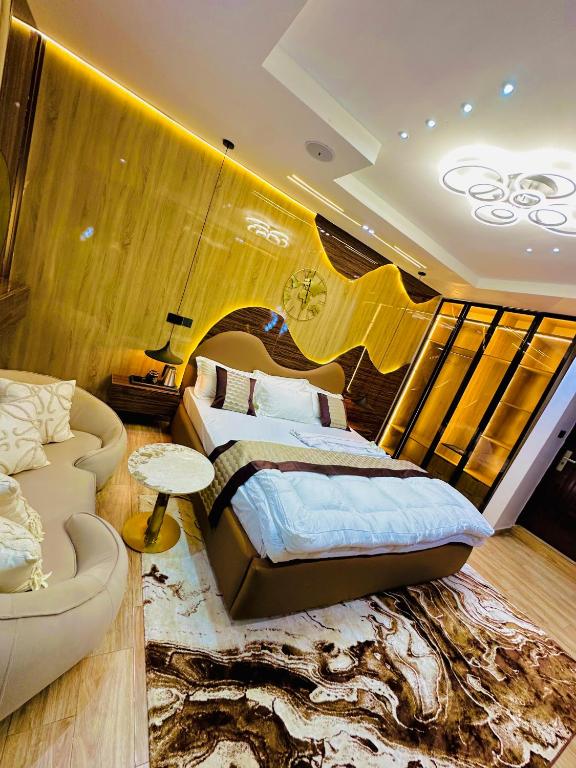 a bedroom with a bed and a couch at Armacruz Luxury Hotel And Apartment in Warri Airport