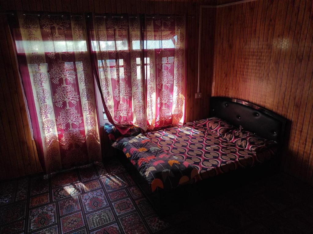 a small bed in a room with a window at Alpine Adventures Guest House Gurez in Gurais