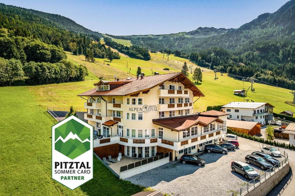 an aerial view of a hotel with cars parked in a field at Hotel Alpen Royal Jerzens in Jerzens