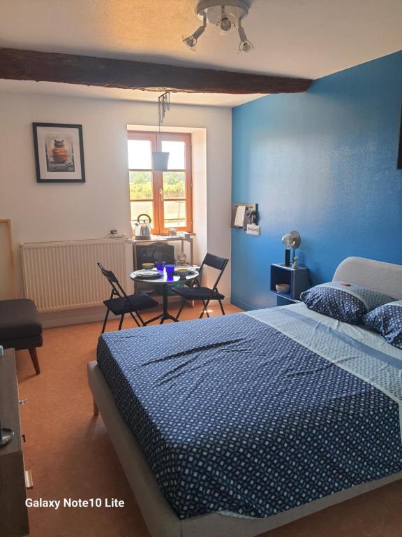 a bedroom with a bed and a table with chairs at Montgrailloux - Chambilly in Chambilly
