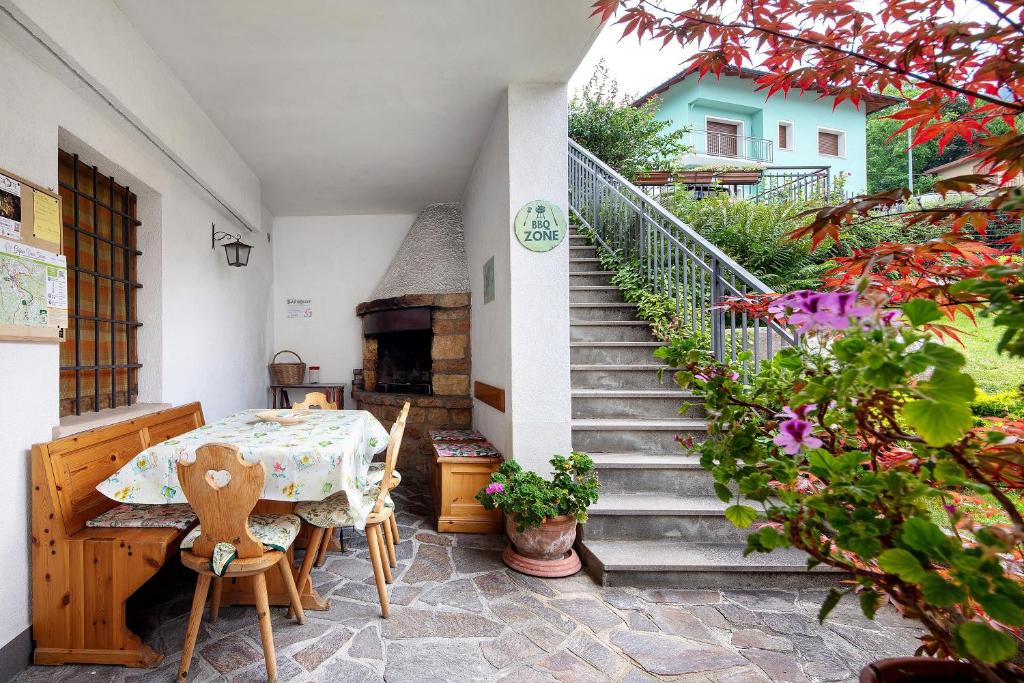 a patio with a table and a pizza oven at Casa Heidi in Castello Tesino