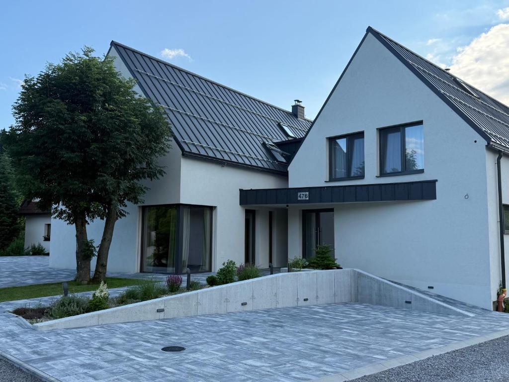 a white house with a solar roof at Jamy House in Habovka
