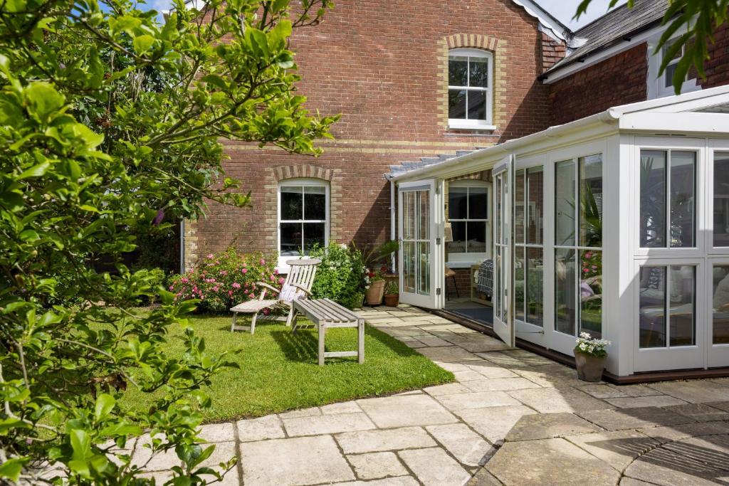 a conservatory with a bench in the yard of a house at Forest View in Brockenhurst