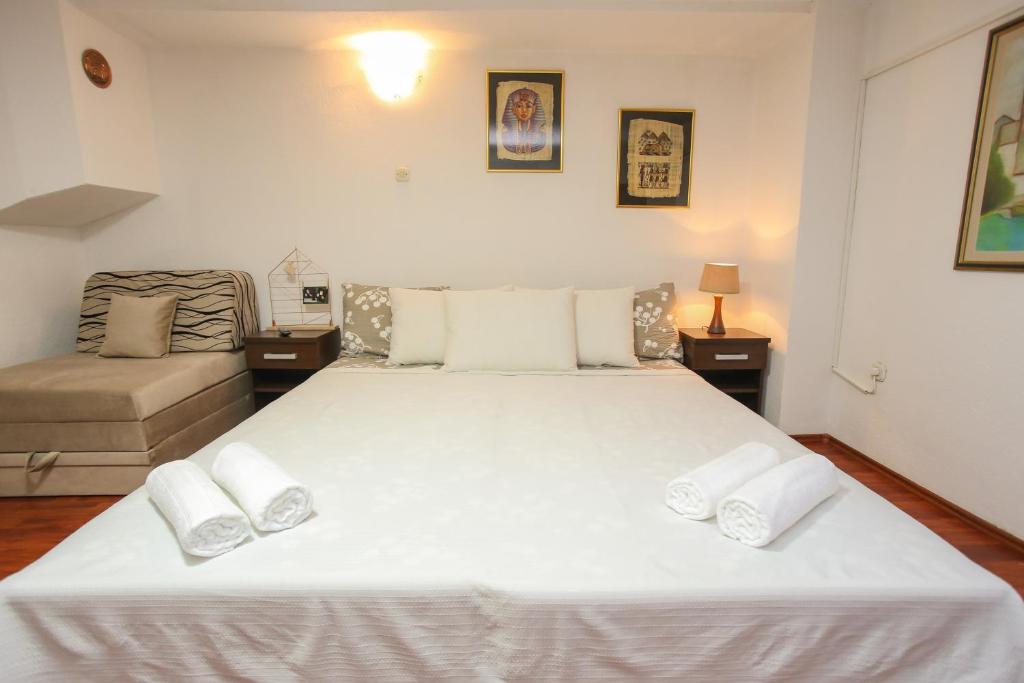 ein Schlafzimmer mit einem großen Bett mit weißer Bettwäsche und Kissen in der Unterkunft Apartment Pajevic in Mostar