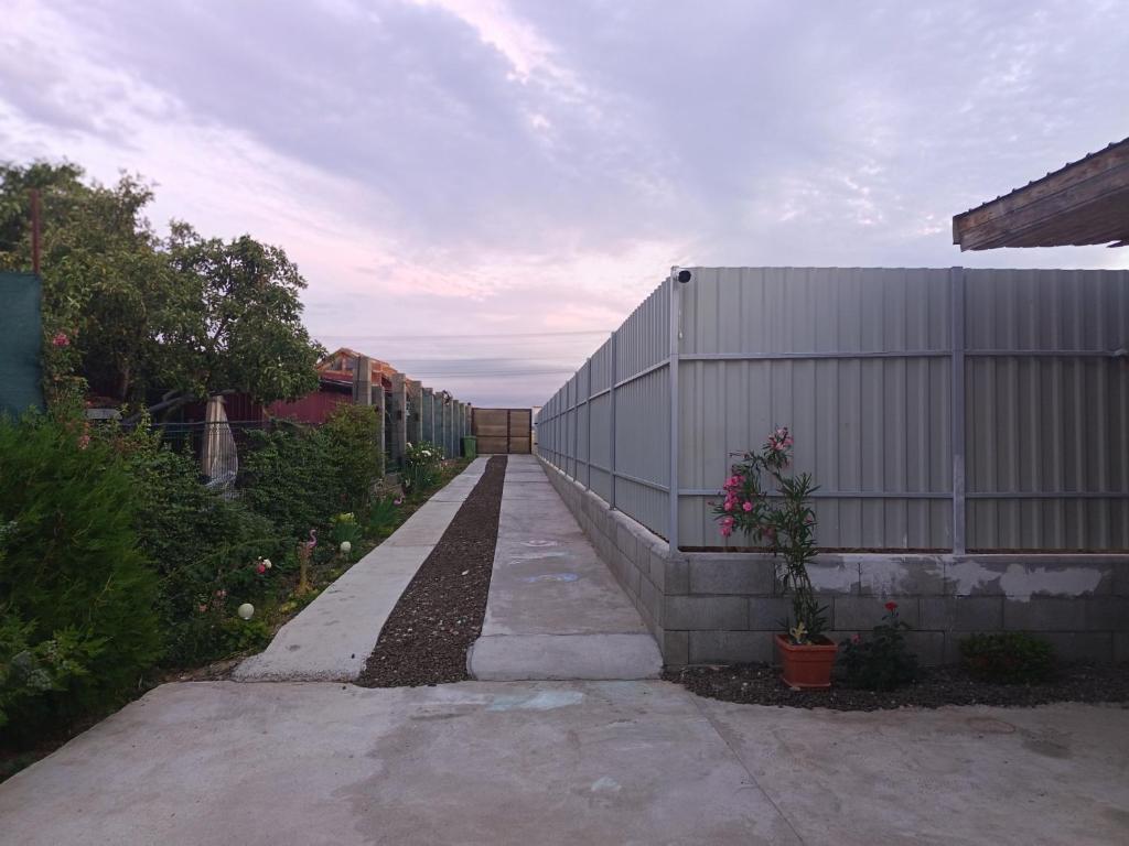 a long walkway next to a white building at Mini vacanta in Tăşnad