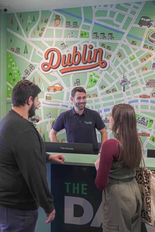 a group of people standing around a table with a dullin sign at The Dawson Hostel - DUBLIN in Dublin
