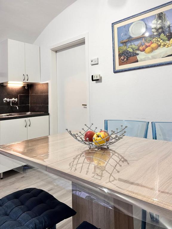 a kitchen with a table with a bowl of fruit on it at Casa Christa in Castello di Fiemme