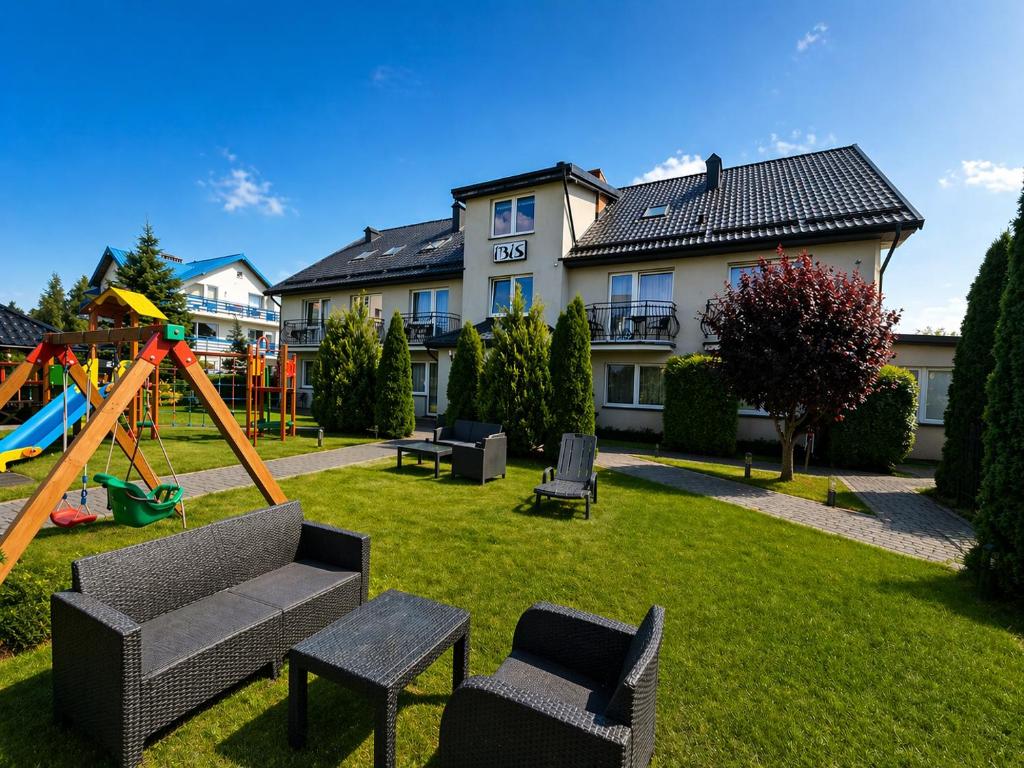 a yard with a playground with a swing at Willa Ibis in Karwia