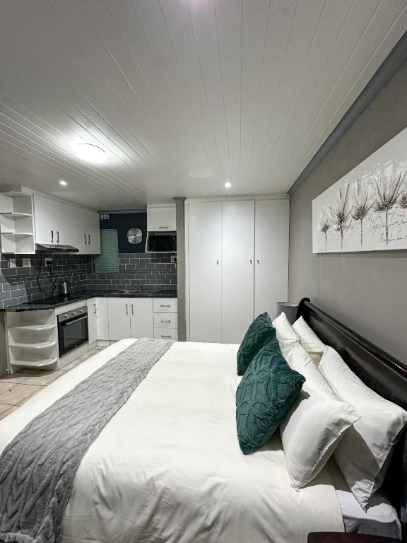 a bedroom with a large white bed with pillows at Sir Galahad Flatlet 2 in Camelot in Silver Sands