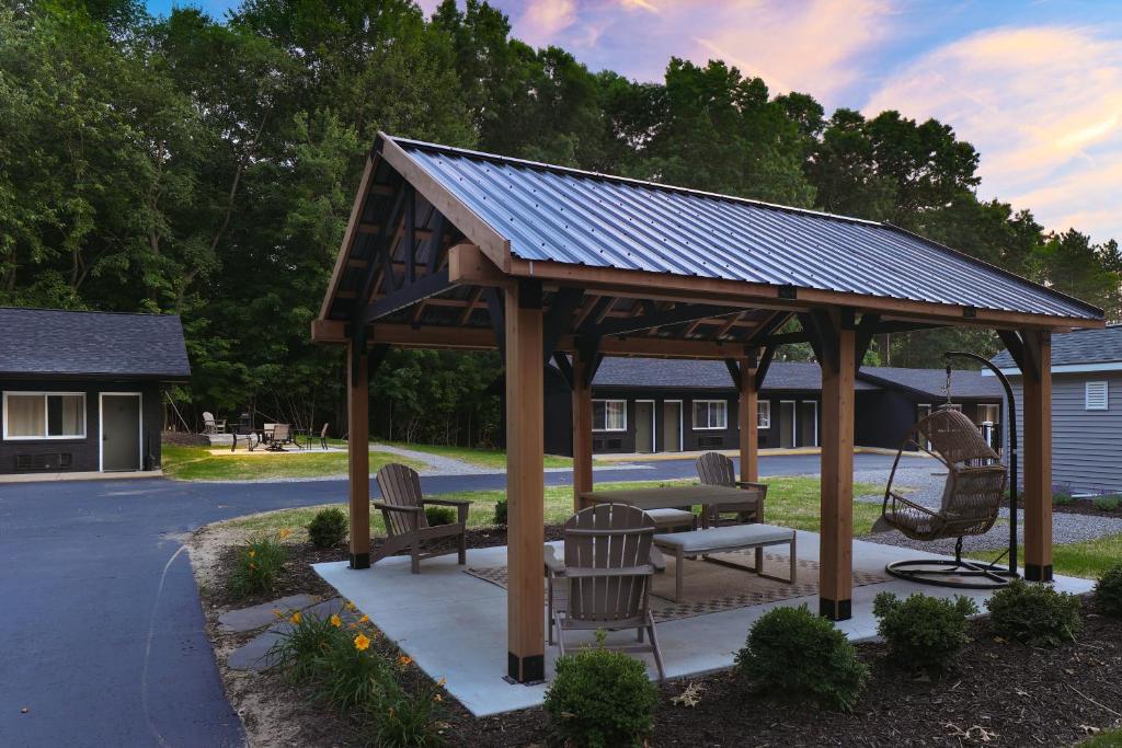 a wooden gazebo with chairs and a bench at The Warren Hotel in Bridgman