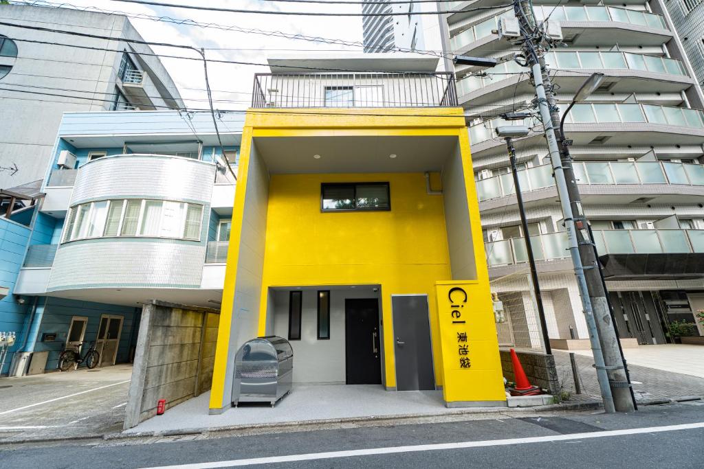 a yellow building on the side of a street at Ciel東池袋 in Tokyo