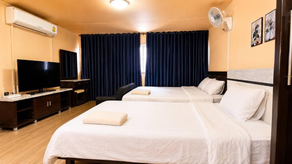 a hotel room with two beds and a flat screen tv at อิมแพ็ค เมืองทองธานี ห้องเช่ารายวัน เมืองทอง popular condo C5 in Ban Bang Phang