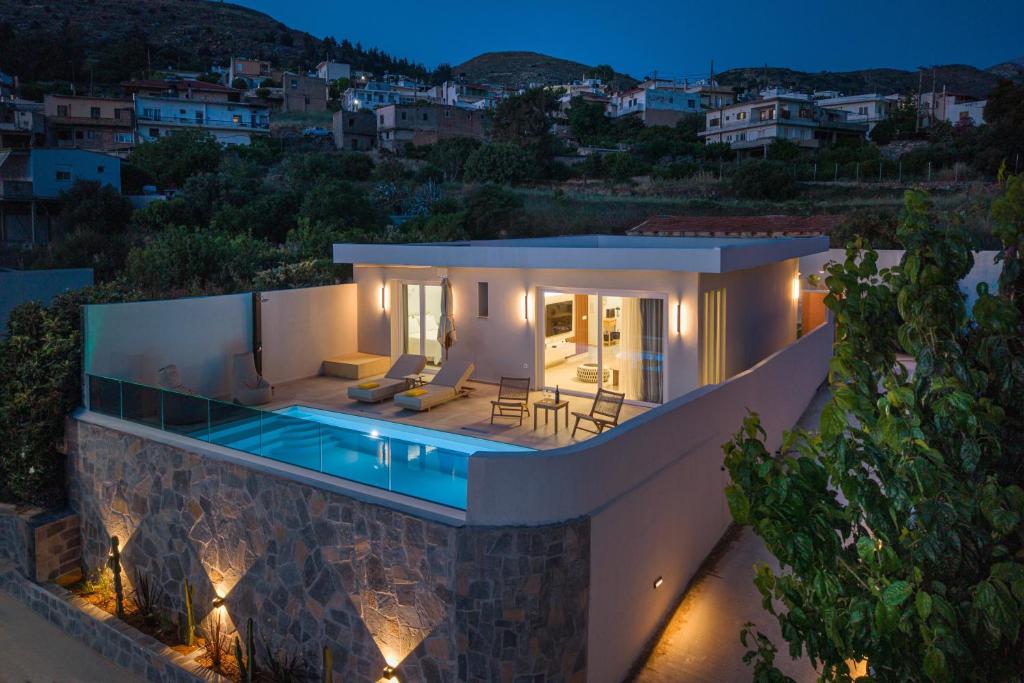 a villa with a swimming pool at night at Terra Falconis in Nipidhitós