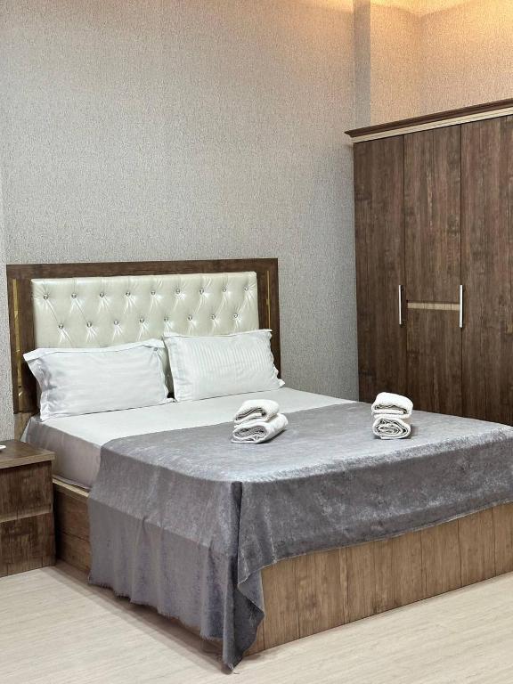 a bedroom with a large bed with two towels on it at Ситора in Dushanbe