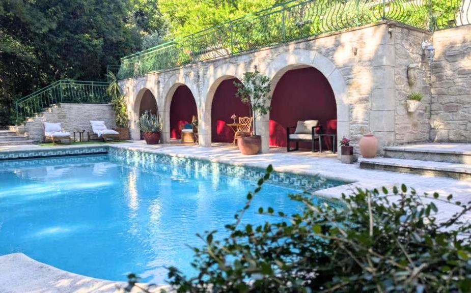 a swimming pool in a yard with a building at Le Moulin des Salces in Saint-Privat