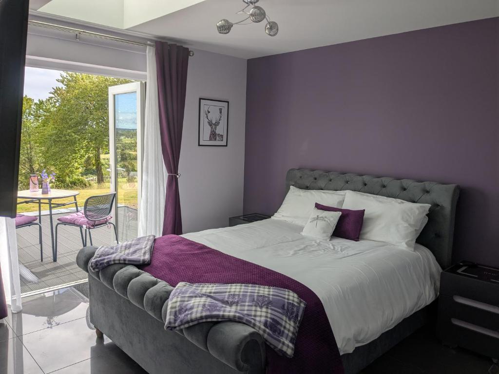 a bedroom with a bed and a balcony with a table at An Airigh Bed & Breakfast in Kirkhill