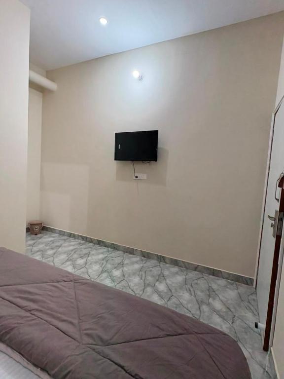 a bedroom with a flat screen tv on the wall at aadi shakti palace in Faizābād