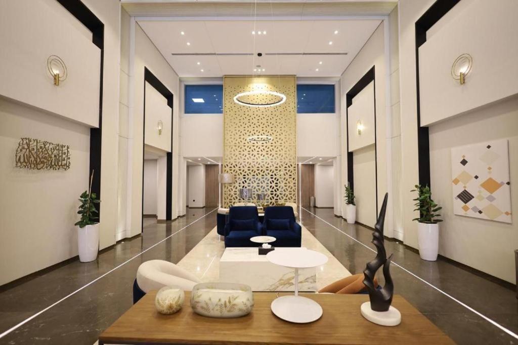 a lobby with a table and chairs in a building at شقه دار المشاعر فى دار الاركان لشقق لاكجرى in Mecca