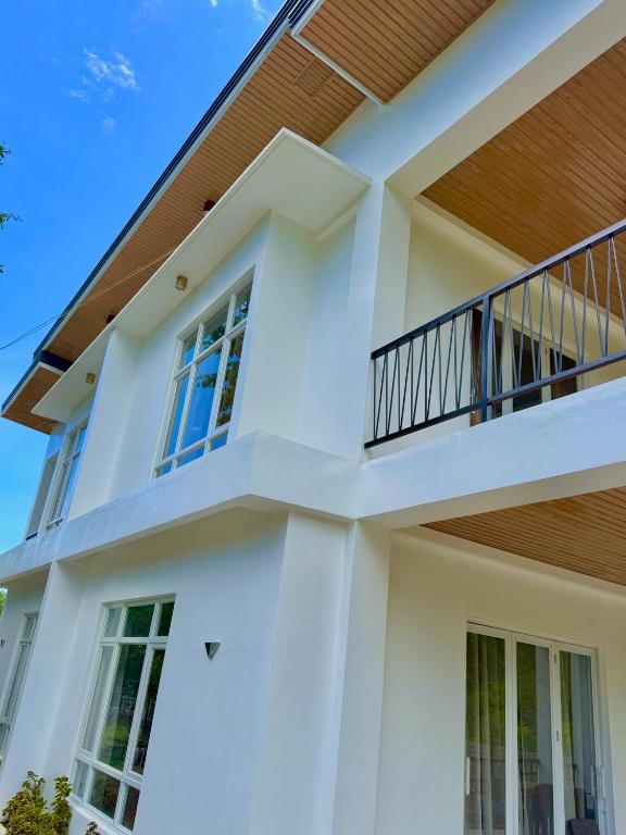 a white house with a balcony at Central 1 Suites in Mambajao