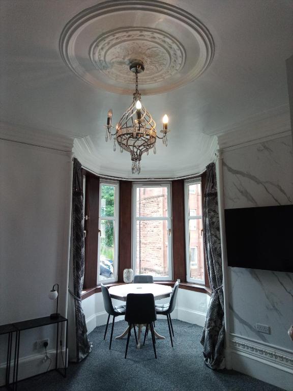 a dining room with a table and chairs and a chandelier at Beautiful 2 double bedrooms, 2 baths apartment in Port Glasgow