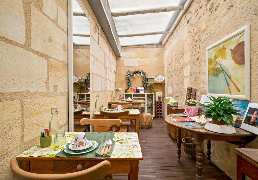 a room with tables and chairs in a building at B&B Le Miroir aux Fées Bordeaux in Bordeaux