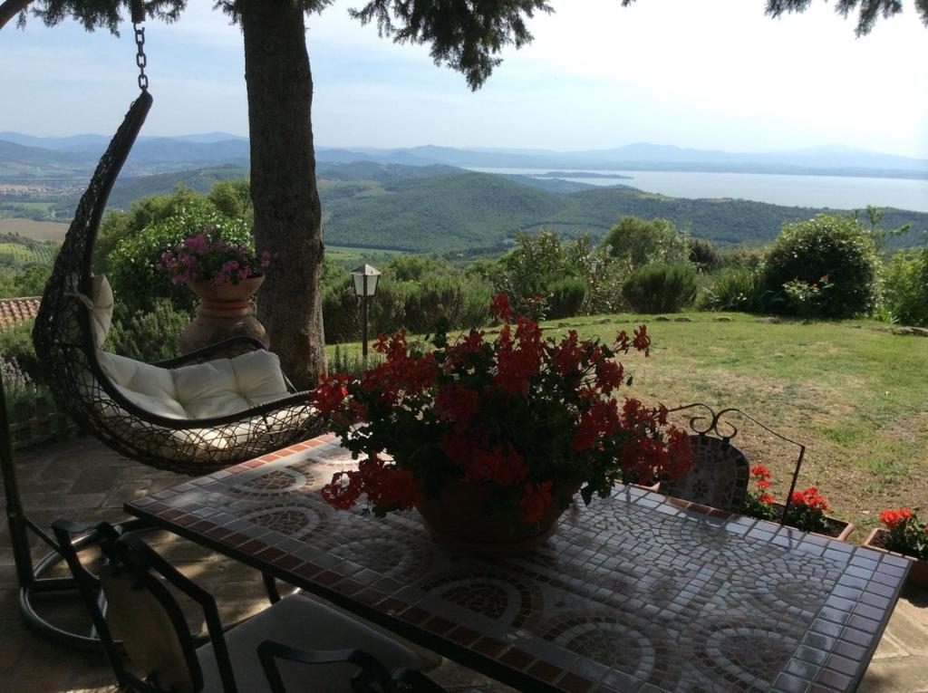 d'une terrasse avec un hamac et une table fleurie. dans l'établissement Agriturismo La Bicocca - Apt. "Il Leccio", à Castel Rigone