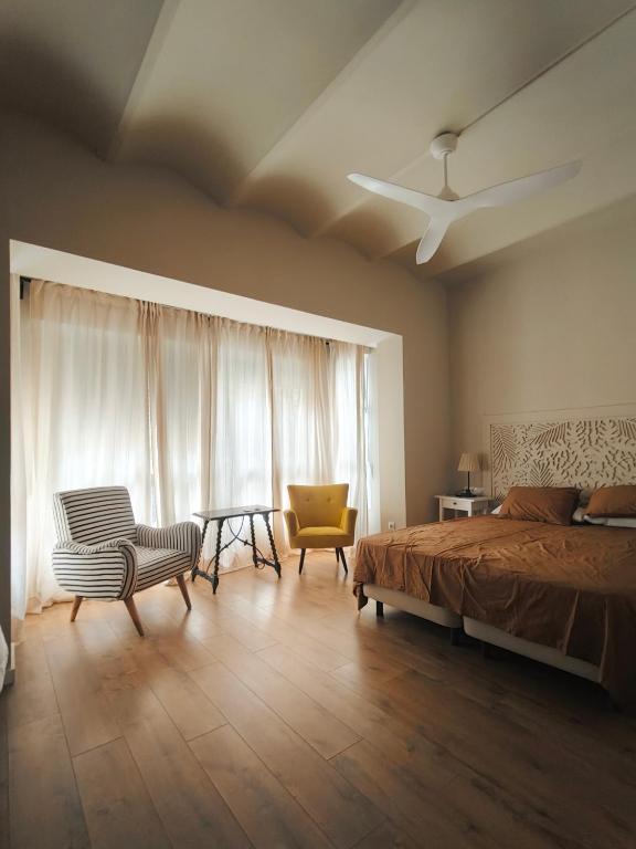 a bedroom with a bed and a table and chairs at Casa Reina Cabanyal in Valencia