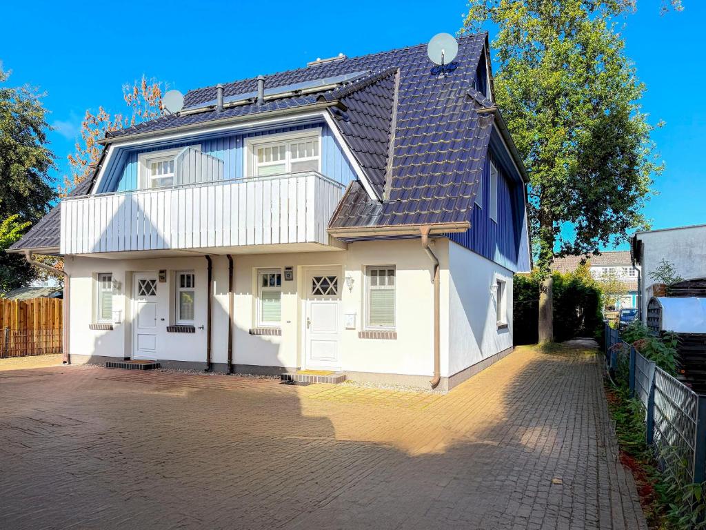 a white house with a black roof at Ferienhaus Meeresrauschen in Groß Kirr