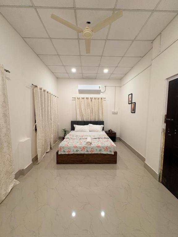 a bedroom with a bed and a ceiling fan at Heritage Home in Guwahati