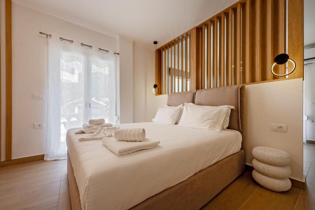 a bedroom with a large white bed with towels on it at Elysian suite in Parga