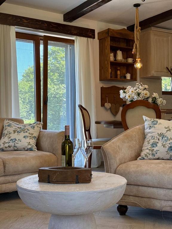a living room with couches and a table with a bottle of wine at Villa Elena in Cetinje