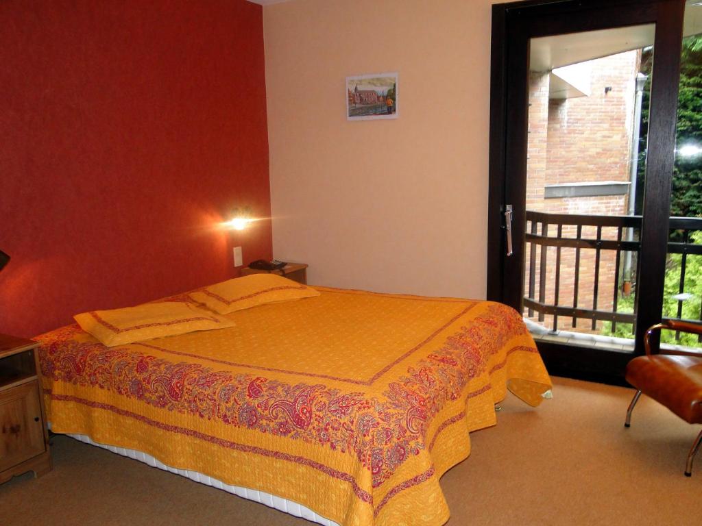 Schlafzimmer mit einem Bett und einem Fenster in der Unterkunft Hôtel du Fort in Huy