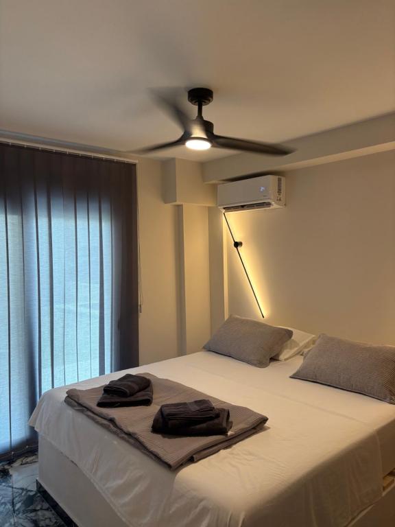 a bedroom with a bed with a ceiling fan at Sweet Suites in Nea Peramos