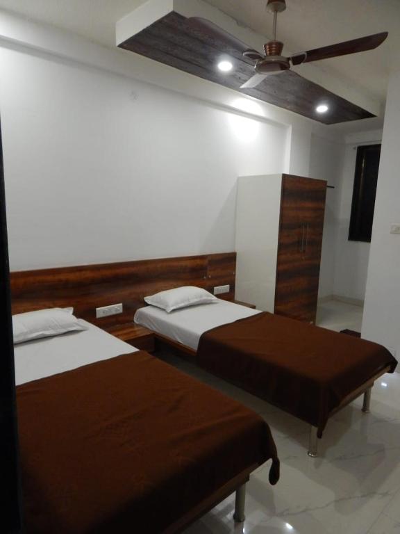 a bedroom with two beds and a ceiling fan at Rutam villa in Shendi