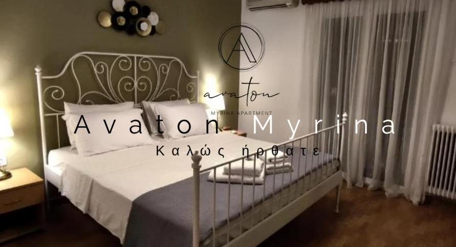 a bedroom with a white bed with a metal headboard at Avaton Myrina Apartment in Myrina